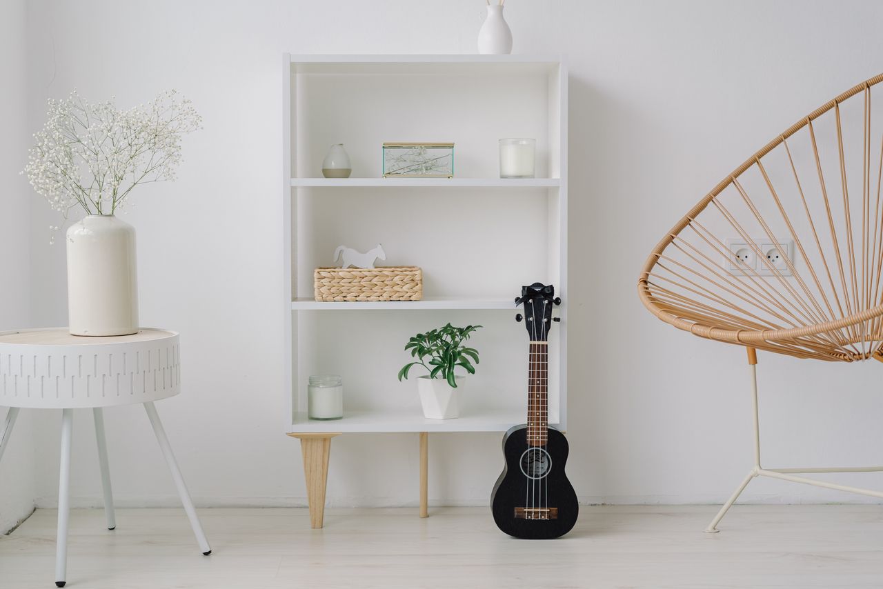 services-03 A modern minimalist living room setup featuring a ukelele, shelves, and stylish decor.