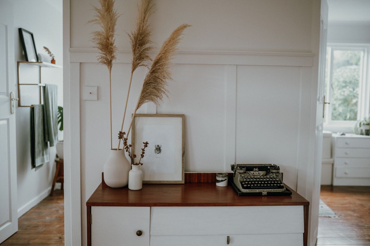 hero-img-01 Elegant Scandinavian interior with pampas grass and vintage typewriter decor.